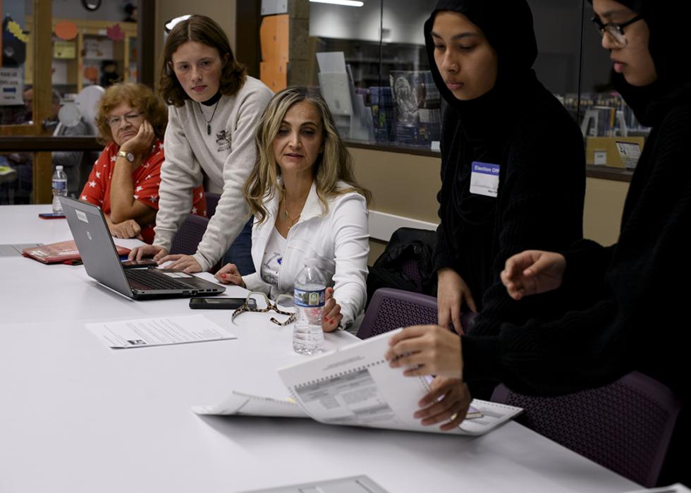 Warren City Clerk Sonja Djurovic Buffa assists poll workers as they reconcile the final ballot count with the reported numbers on the tabulation machines at the conclusion of Election Day at the Dorothy Busch Library in Warren, Michigan, on November 5, 2024.