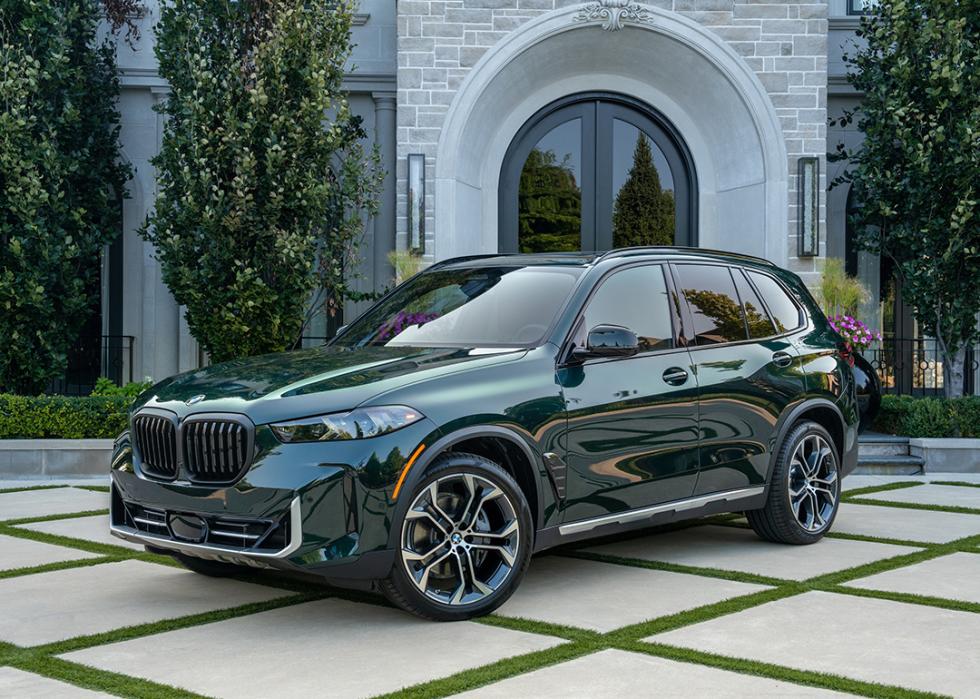 Dark green BMW X5 parked in front of home. 