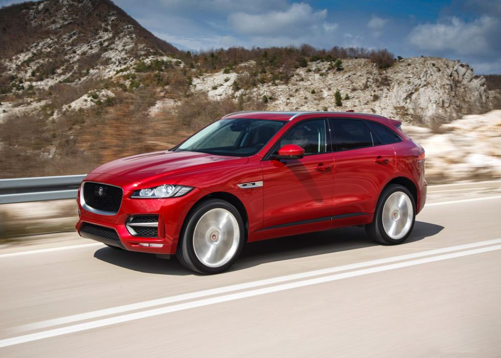 Red Jaguar F-Pace driving on the road.