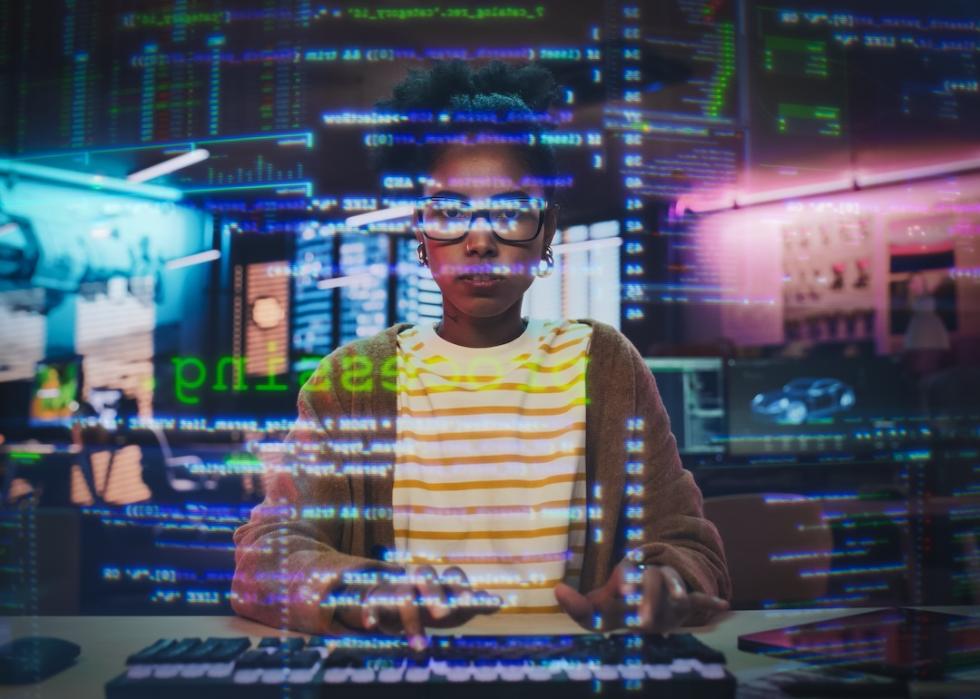 A woman programmer looks pensive trying to problem-solve at her computer.