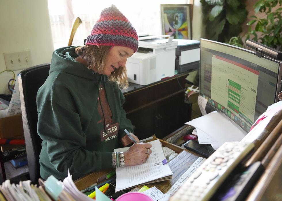 Jennifer Davila, owner of La Posada Pintada, checks in a customer at her hotel in Bluff.