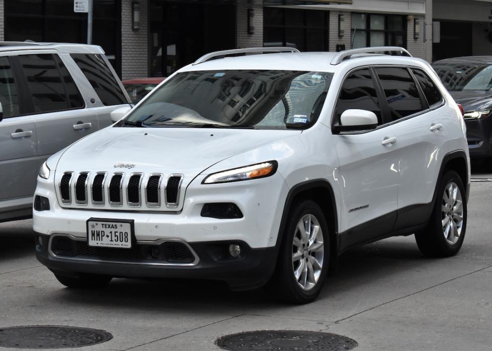  A white Jeep Compass sport utility vehicle, cruising in the downtown financial district of Houston.