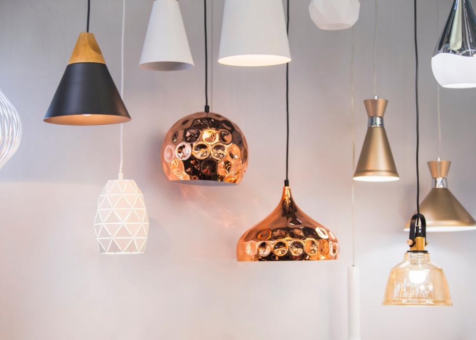 Differently shaped modern lamps hang along a wall.