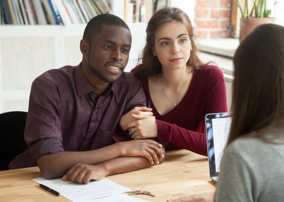 A young couple speaking to a financial counselor.