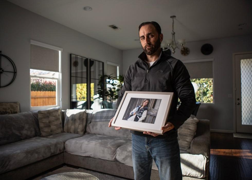 Jerrod Tejeda holds a framed photo of his daughter Cassi Tejeda.