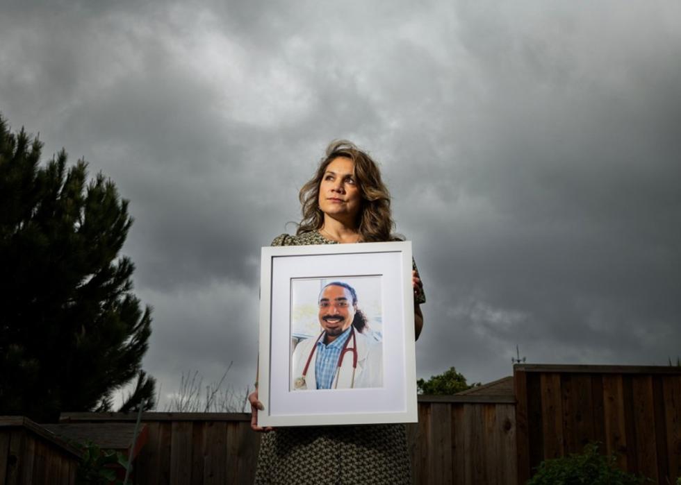 Nora Lopez holds a framed photo of her son, Dr. Dominic Lopez-Toney at her home in Castro Valley.