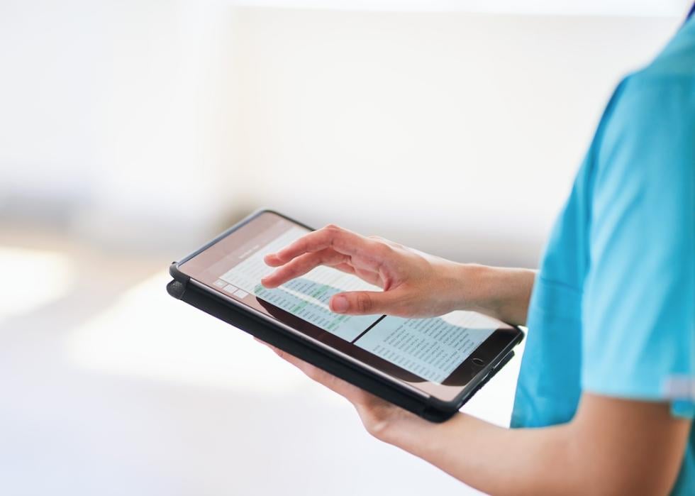 Medical professional using tablet for digital health records.