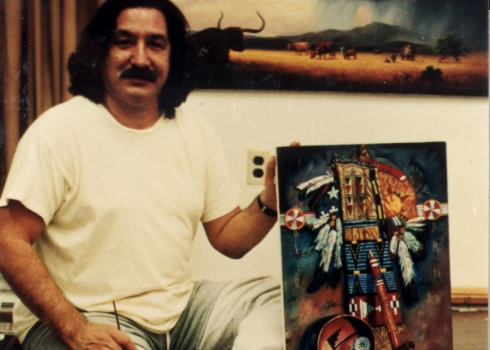 American Indian Movement activist Leonard Peltier posing with a painting, circa 1985.