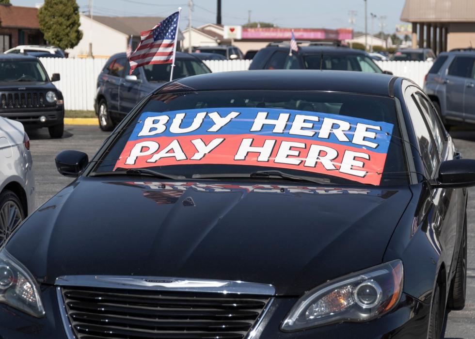 Used car for sale with big signs on the windshield that say Buy here Pay Here