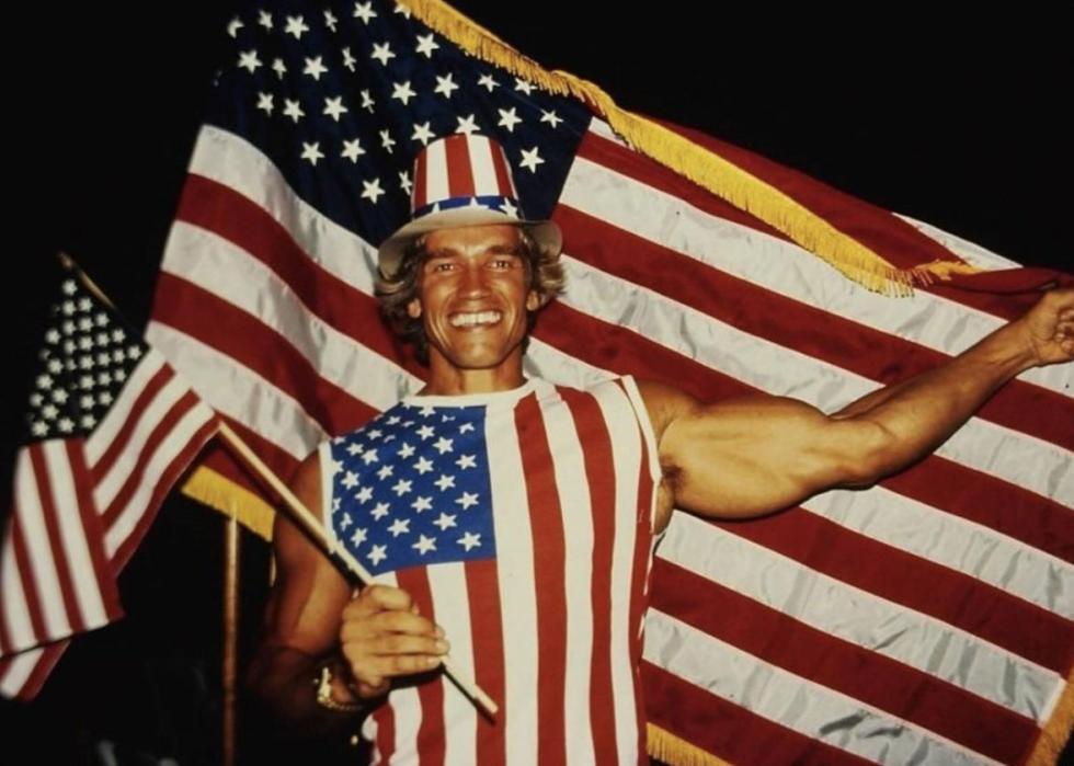 Arnold wearing an American flag hat, shirt, and holding a small American flag