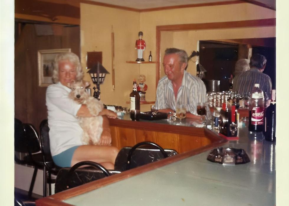 An older couple sitting around in their basement bar