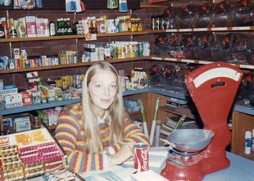 Woman wearing a striped swearing sitting behind the counter at a grocery store