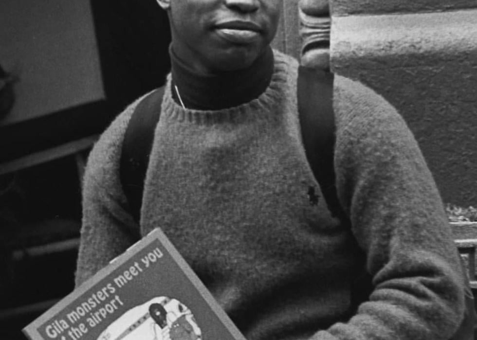 Black and white photo of LaVar Burton holding a book titled "Gila monsters meet you at the airport"