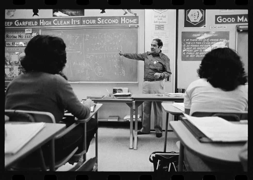 Math teacher pointing at a chalk board