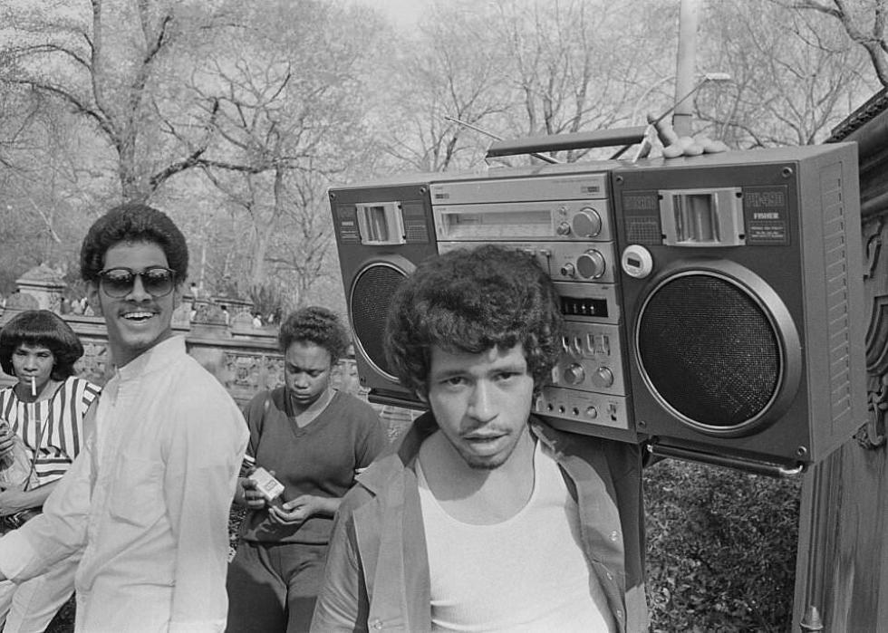 Young man hanging out in central park with a boombox on his shoulder in 1981