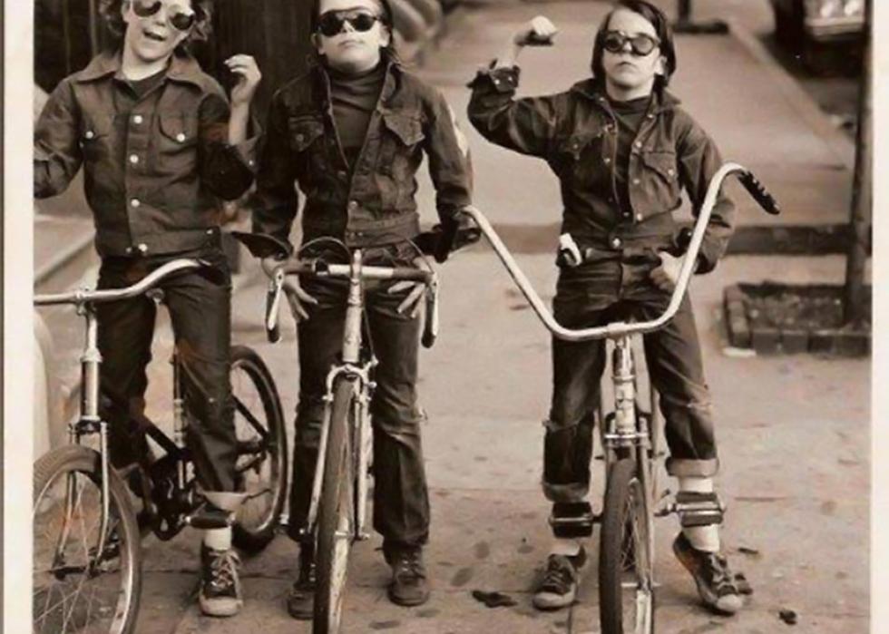 Three kids on bikes wearing sunglasses and denim jackets