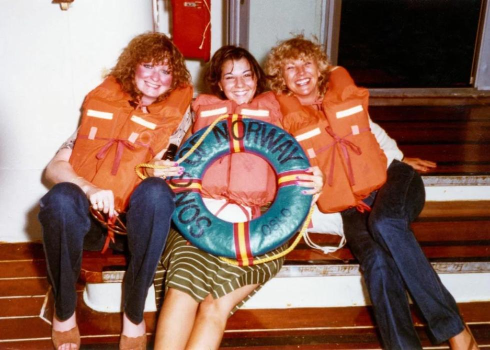 Three woman with life vests on pose for a photo