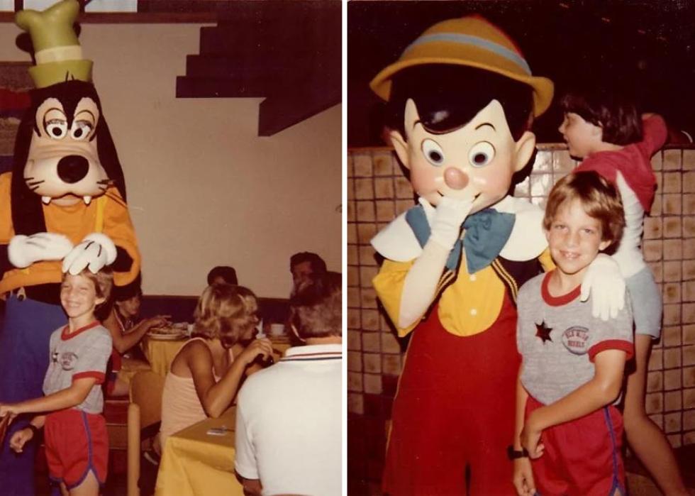 A kid at Disney World with Goofy and Pinocchio
