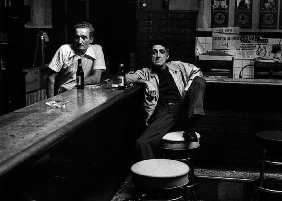 Black and white photo of a bartender and a patron at a bar
