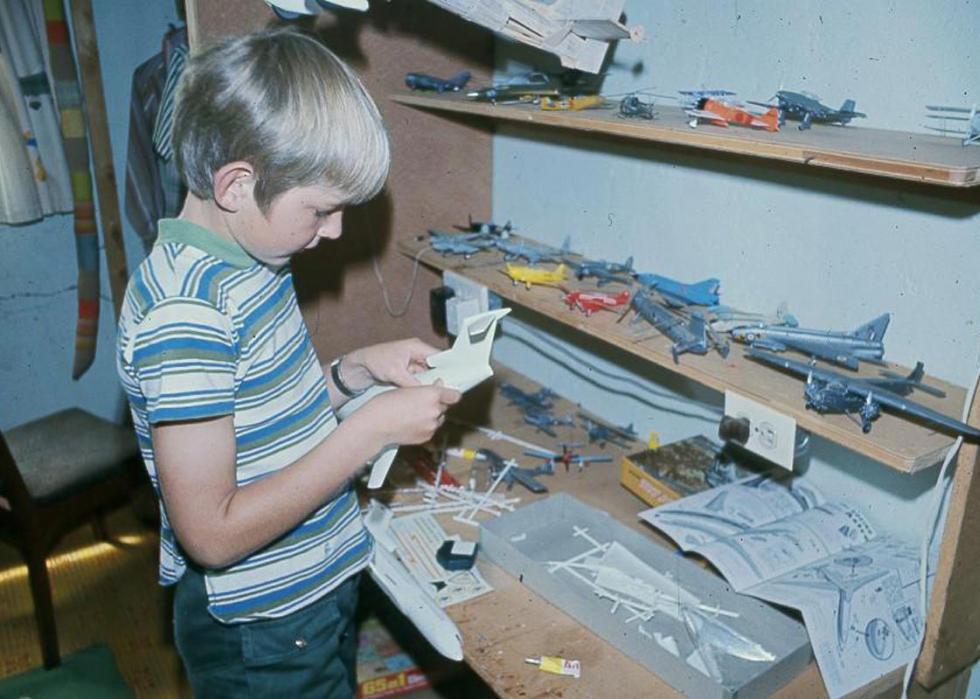 A boy putting together model planes