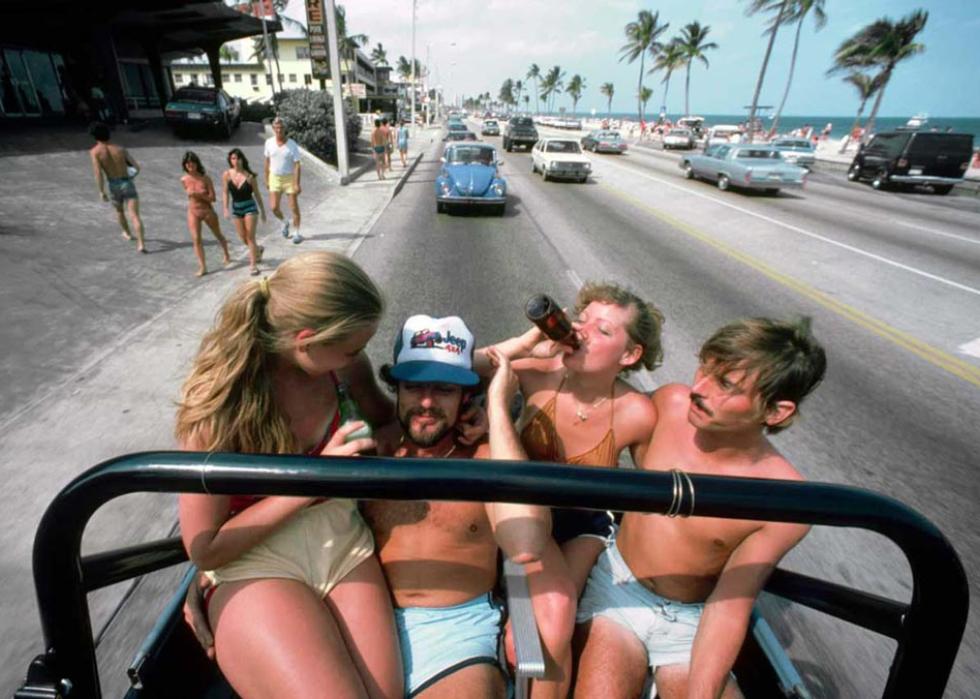 Four young people sitting in the back of a jeep 