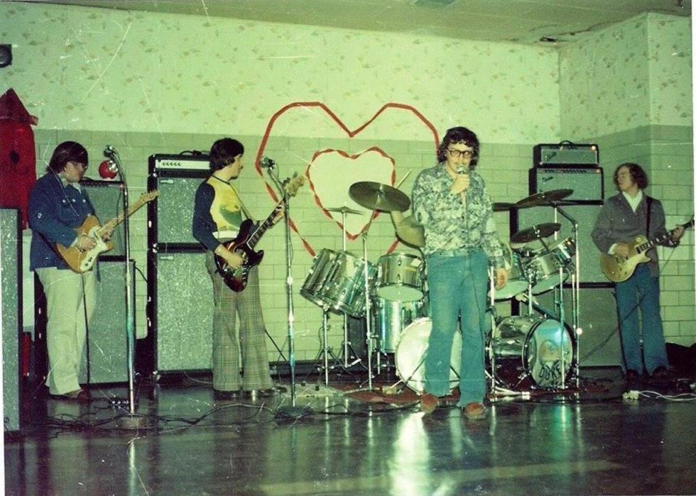 Four guys performing in a band at a school dance