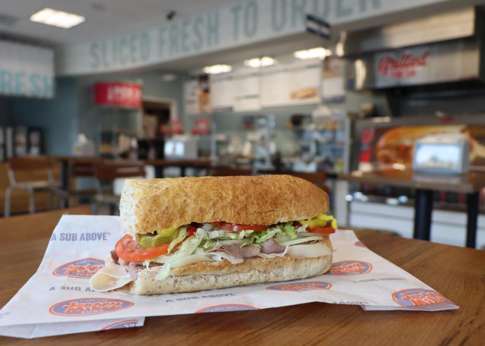 A Jersey Mike's sub sandwich sitting on a table inside a restaurant