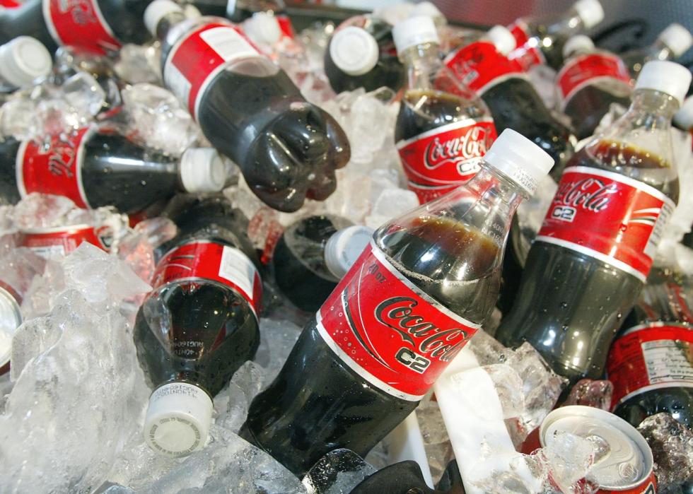 Multiple bottles of Coca-Cola C2 chilling on ice.