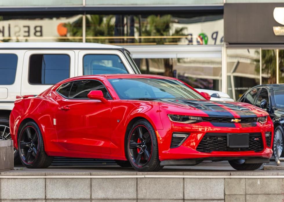 Red Chevrolet Camaro ZL1 supercharged muscle car with black stripe.
