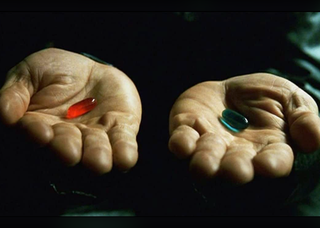Laurence Fishburne’s hands holding red and blue pills in ‘The Matrix’.