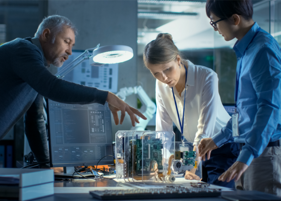 People looking at computer circuitry.