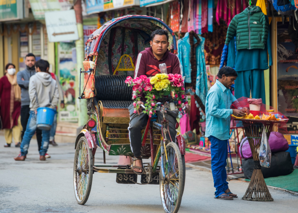 Man driving a bicycle rickshaw on a Kathmandu street