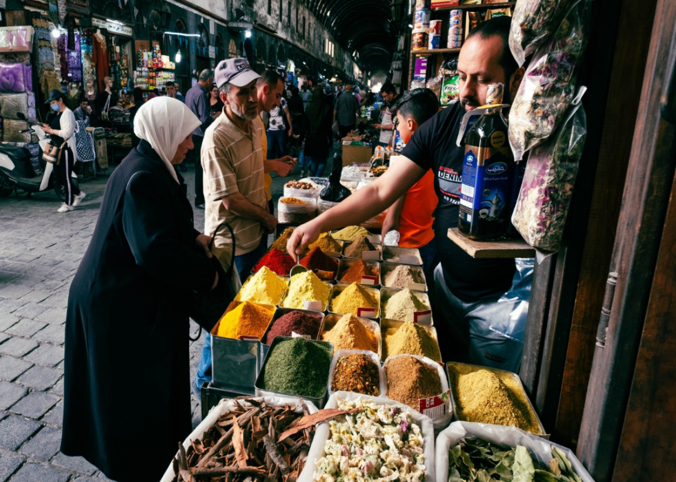 People buying spices at a street market in Damascus