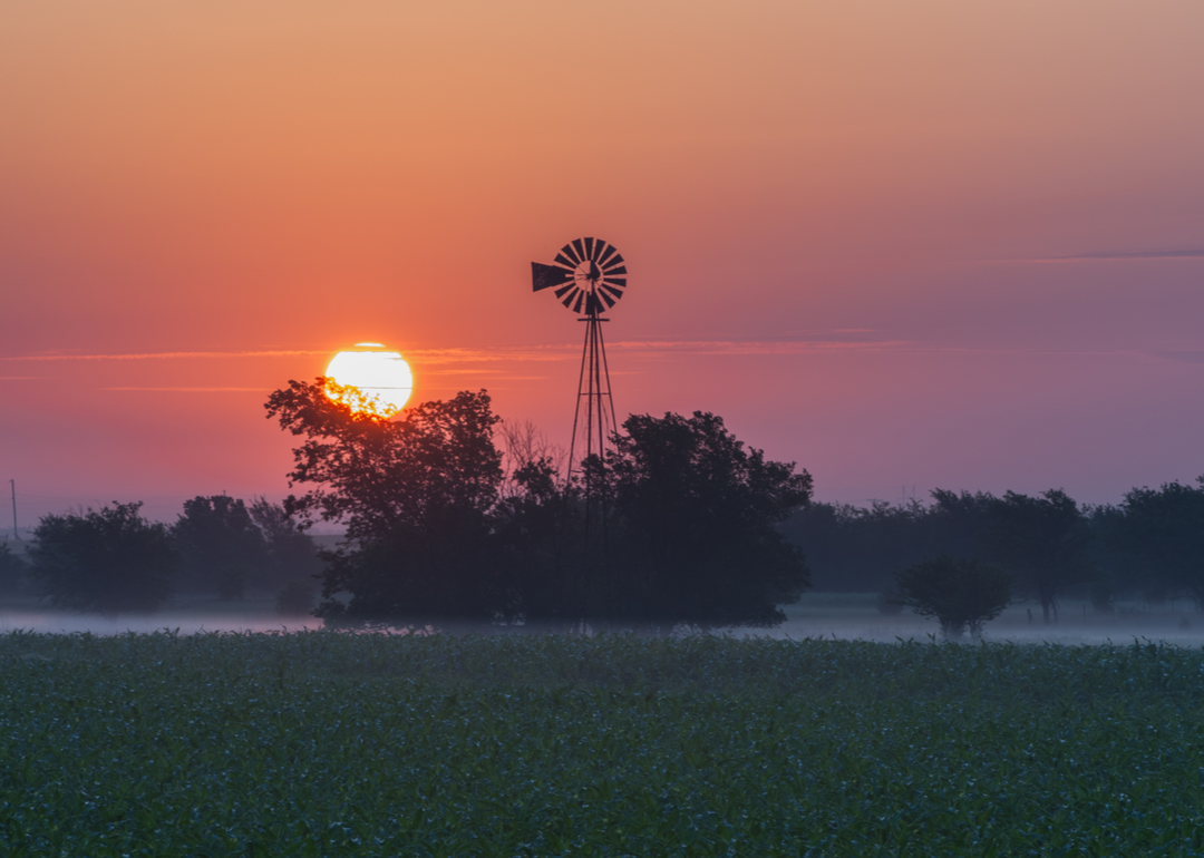 The sun sets on an old windmill