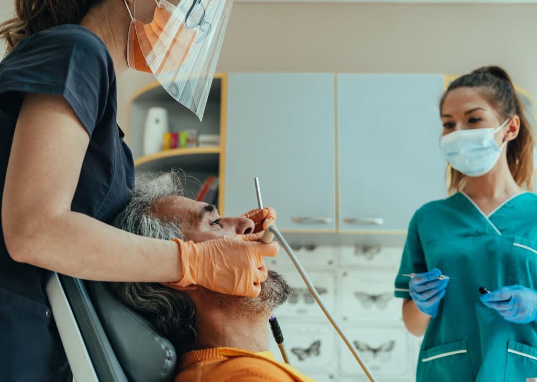 Dentist discussing patient with assistant.