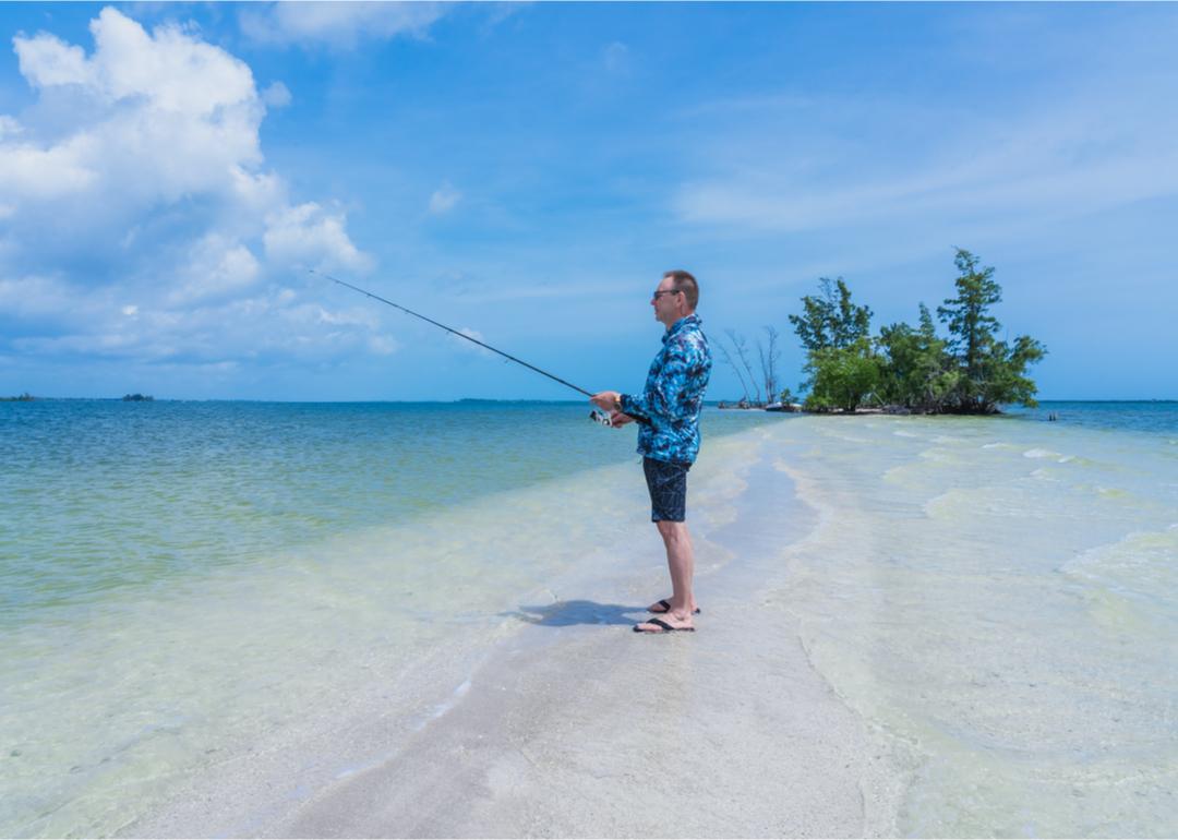 Man standing on beach with fishing rod on Indian River Island.
