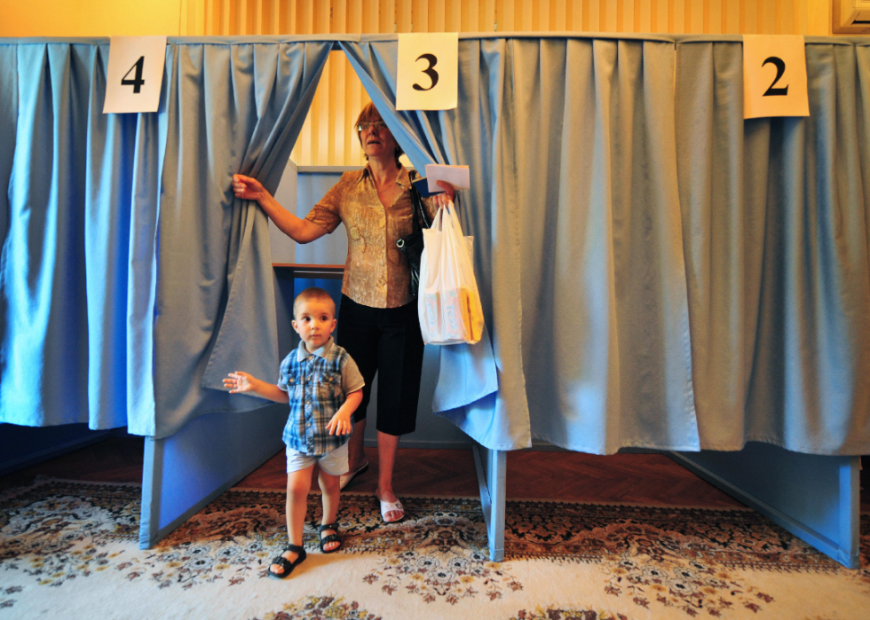 A Moldovan woman and a child exit voting boot