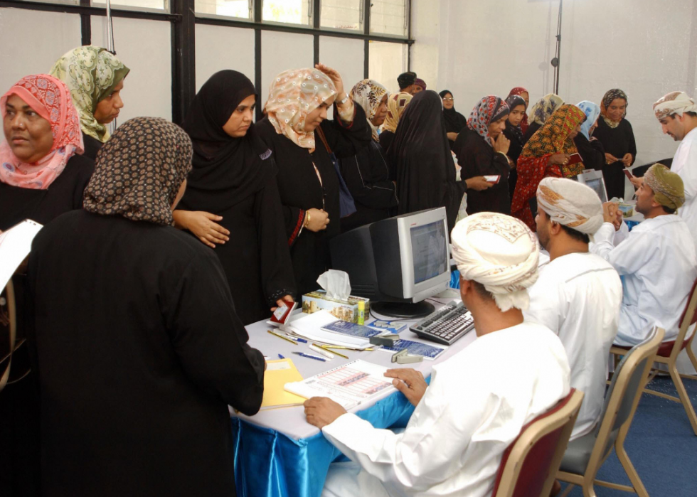 Omani women get their ballots ready to vote at a polling station on Oct. 4, 2003
