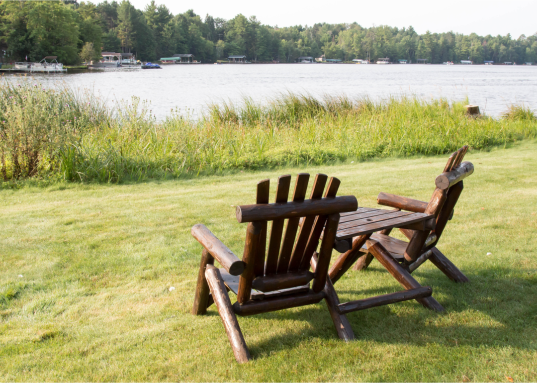 Adirondack chairs sit on a green lawn
