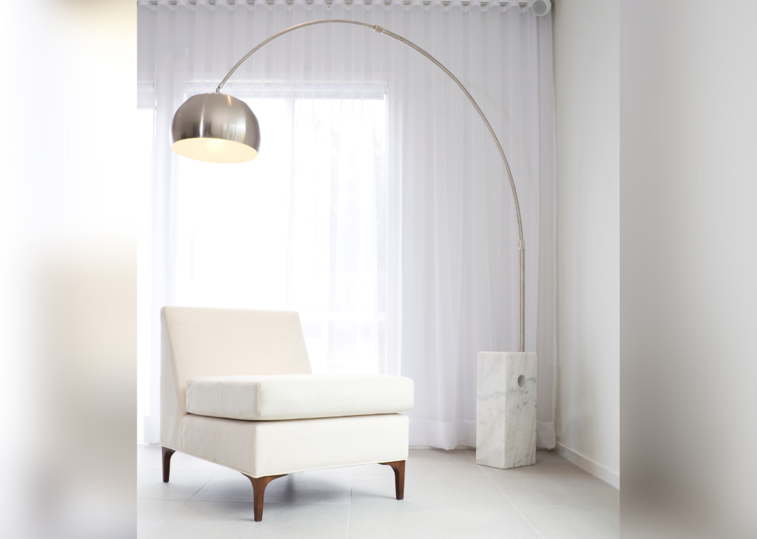 An arco floor lamp in an all white room.
