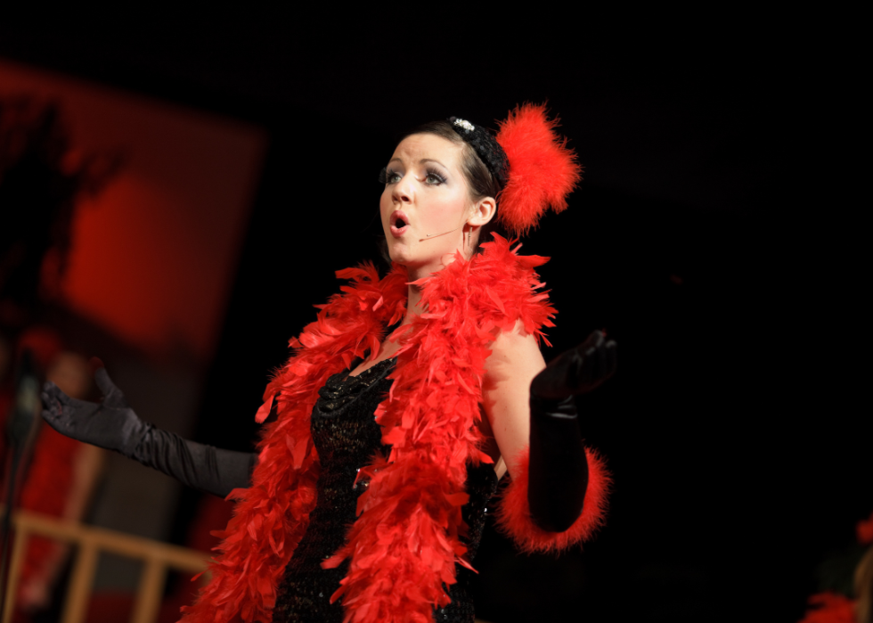 A woman performer singing on stage. 