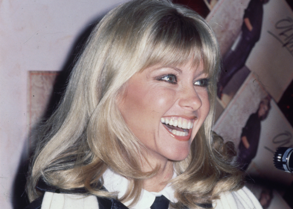 Olivia Newton-John smiles at press conference.