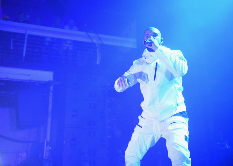 Drake sings into microphone onstage.