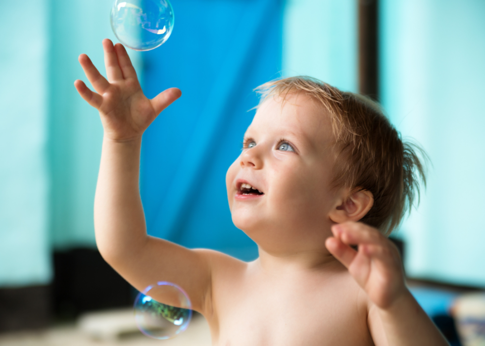 A baby boy playing with bubbles.