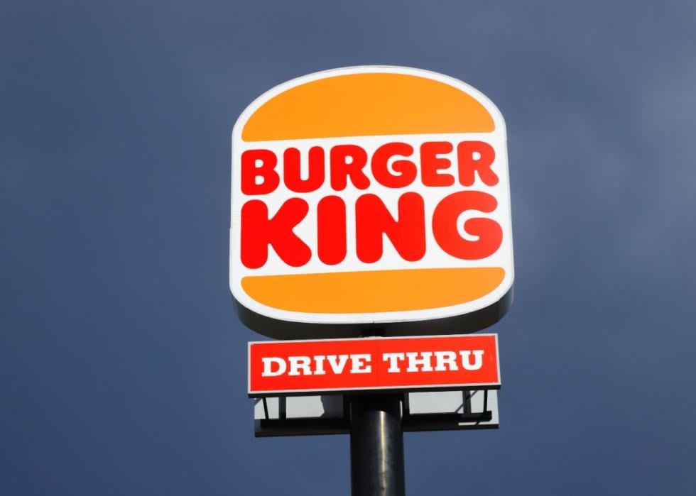 Burger King logo and the words drive thru on a sign at the top of a pole.