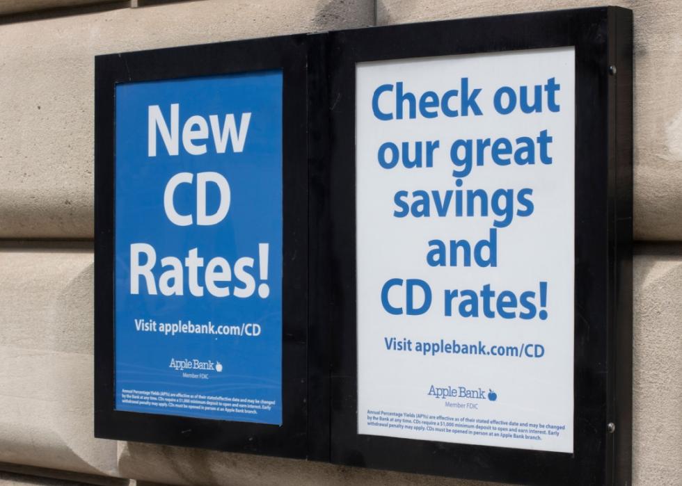 A double-sided sign advertising new CD rates from Apple Bank. The left side of the sign reads "New CD Rates!" and directs viewers to visit applebank.com/CD. The right side of the sign promotes "great savings and CD rates!"