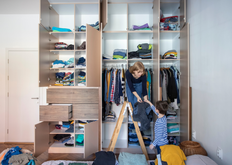 A woman and a child organizing a closet.