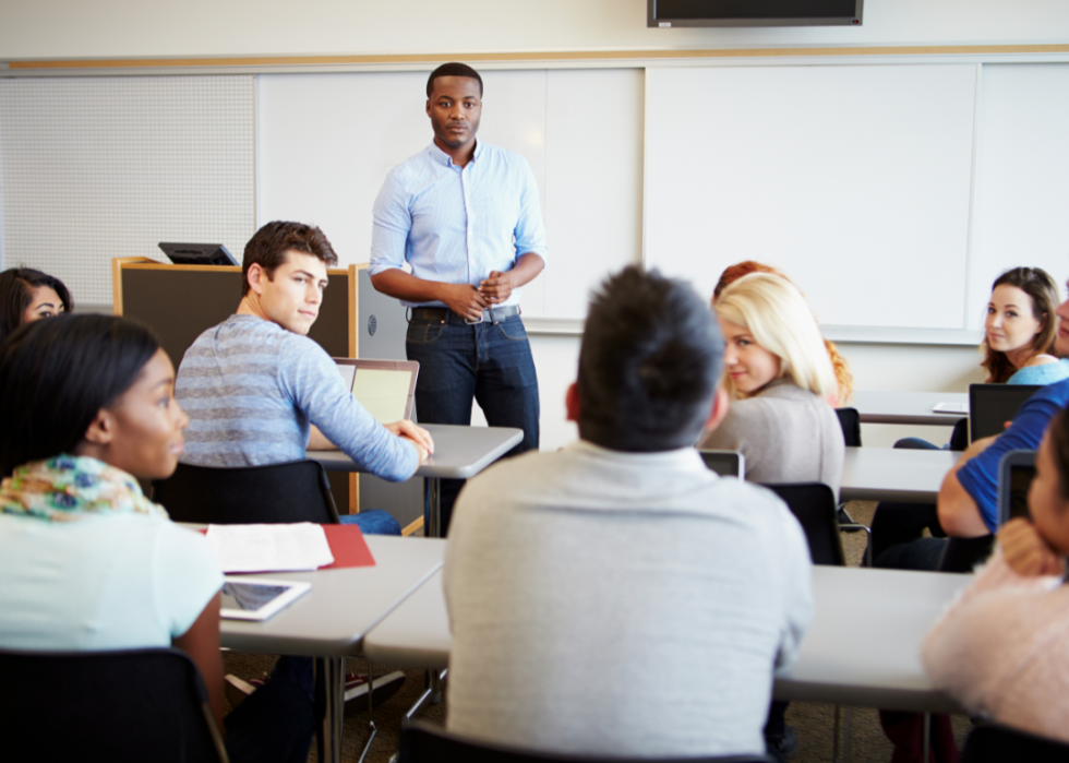 A professor addresses a group of college students.