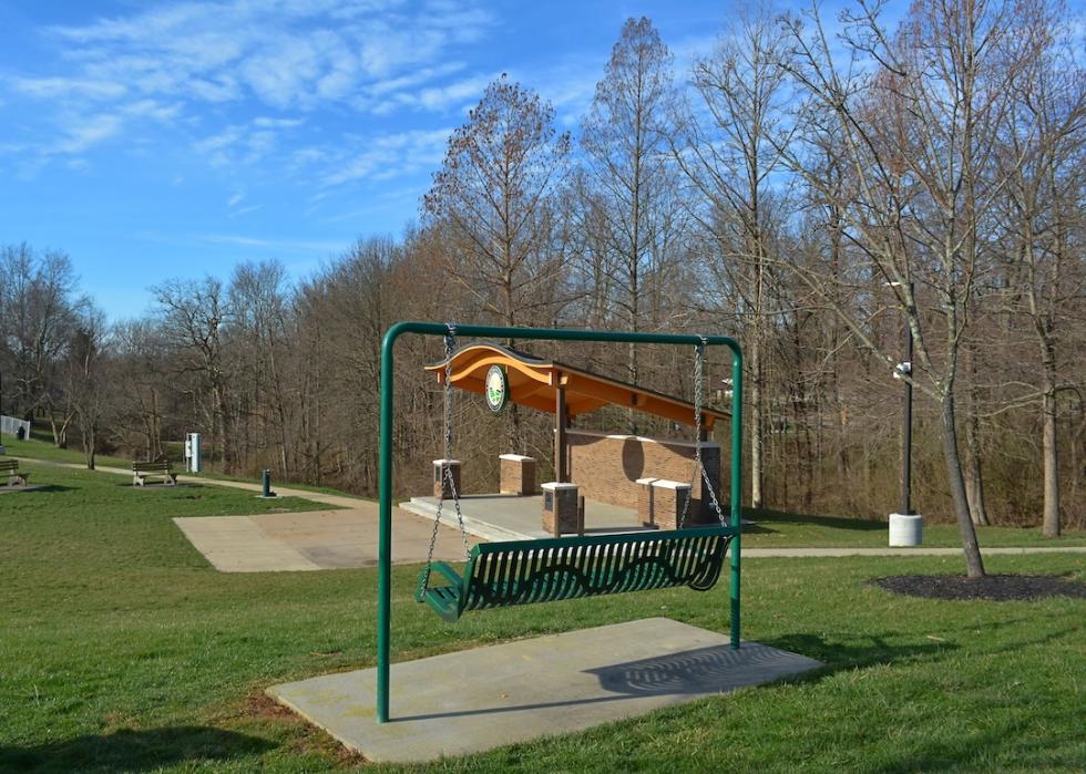 Park with bench swing and stage for local concerts on green grass and blue skies in Edgewood, Kentucky.