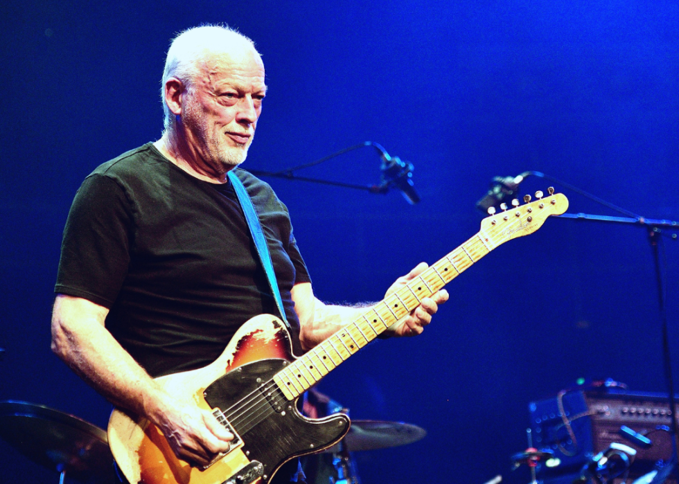 David Gilmour playing the guitar on stage in 2019 in London.